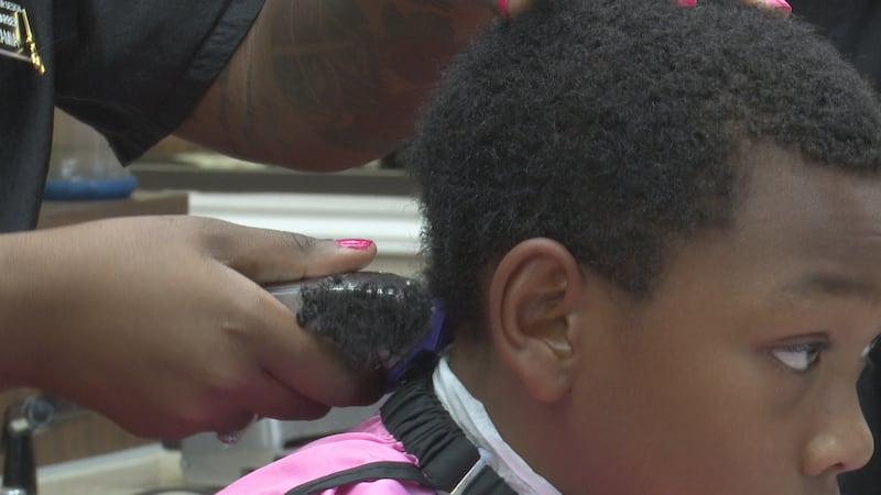 A boy receives a haircut at OG's School of Hair Design in Killeen