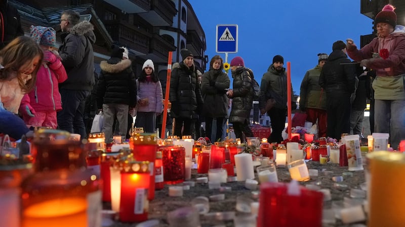 People light candles near the sealed off Le Constellation bar in Crans-Montana, Swiss Alps,...