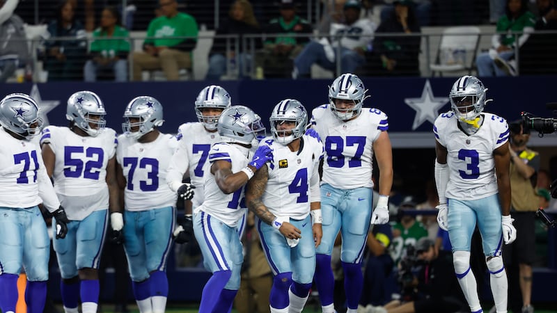 Dallas Cowboys quarterback Dak Prescott (4) celebrates with teammates after a touchdown during...