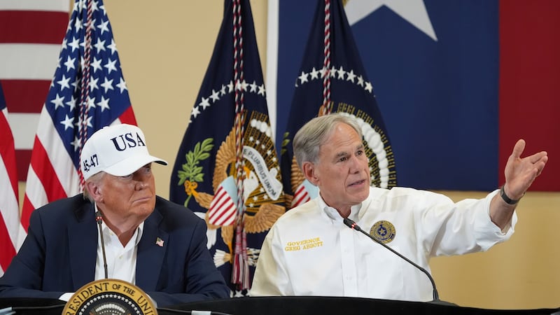 FILE - Texas Gov. Greg Abbott speaks as President Donald Trump listens during a roundtable...